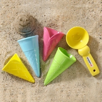 brinquedos de praia em forma de cones de gelado e pá amarela na areia