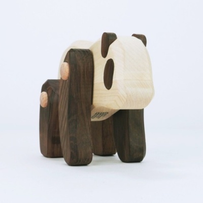 Figura decorativa em madeira castanha e clara com formas geométricas simples.