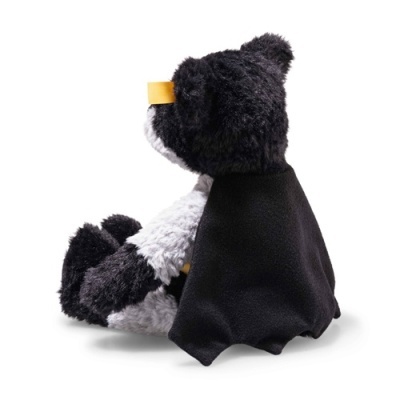 Ursinho de peluche preto e branco com capa preta e faixa amarela nos olhos