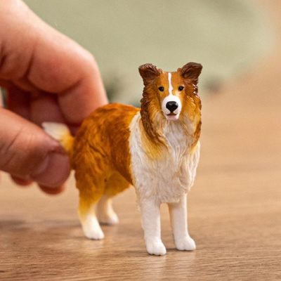 Figura de cão Collie em plástico pintado com uma mão atrás