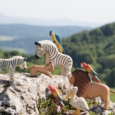 Figuras de animais em madeira em cenário natural sobre rochas