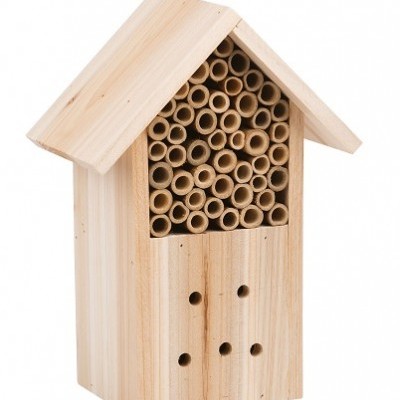 Casa de madeira clara com tubos de bambu e pequenos furos