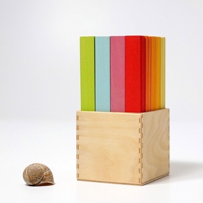 Post-its coloridos em caixa de madeira com caracol ao lado