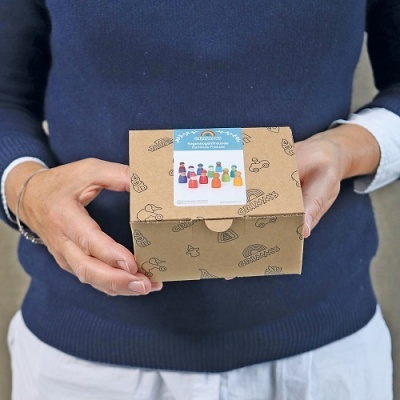 Pessoa segurando caixa de papelão com padrão e etiqueta colorida