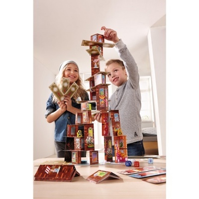 Crianças a construir torre com cartas de jogo em madeira clara