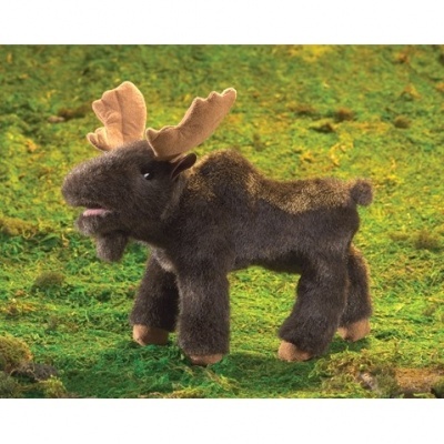 Pelúcia de alce marrom com galhadas bege sobre fundo verde de musgo