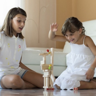 Duas crianças a jogar jogo de blocos de madeira no chão