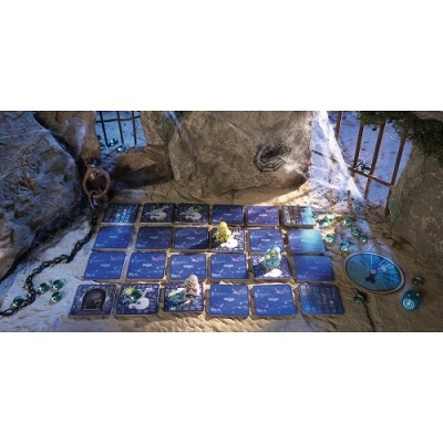 Jogo de tabuleiro com cartas azuis e peças coloridas sobre superfície arenosa com pedras e correntes