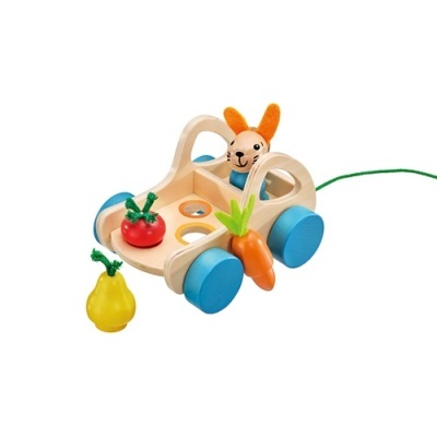Carrinho de brincar em madeira com coelho e legumes coloridos.