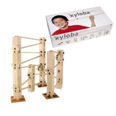 Jogo de construção em madeira clara com cabos elásticos e caixa com imagem da marca xyloba