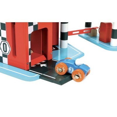 Brinquedo de pista com carro azul e edifício vermelho