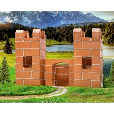 Castelo de tijolos vermelhos num campo verde com lago e montanhas ao fundo