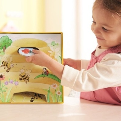 Jogo infantil educativo com caixa em formato de colmeia e uma menina a brincar