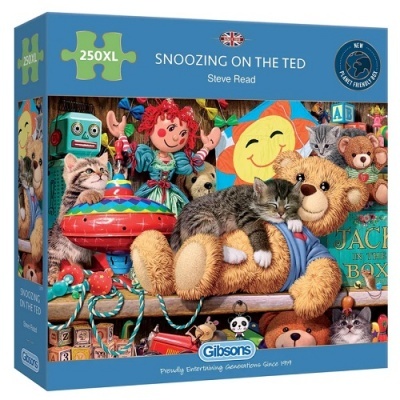 Caixa de puzzle com imagem de urso de pelúcia amarelo a dormir com um gato rodeados de brinquedos coloridos