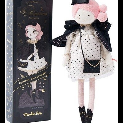 Boneca rosa vestida com roupa branca e preta ao lado da caixa preta decorada