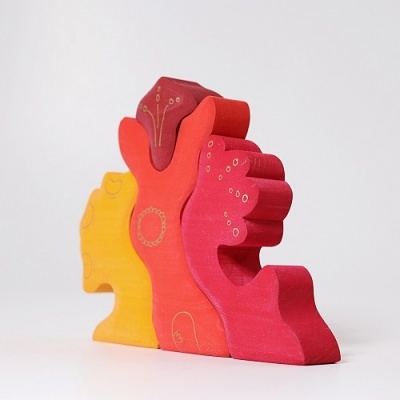 Blocos de madeira coloridos em amarelo, laranja e vermelho com padrões gravados