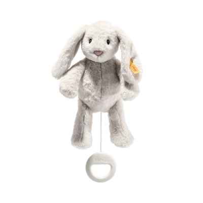 Urso de peluche cinza com olhos pretos e etiqueta amarela num suporte branco com anel