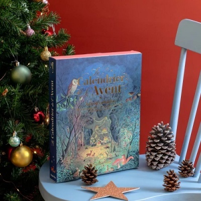 Caixa do Calendário do Advento azul com ilustração de floresta, mesa azul clara com pinhas e estrela, árvore de Natal decorada