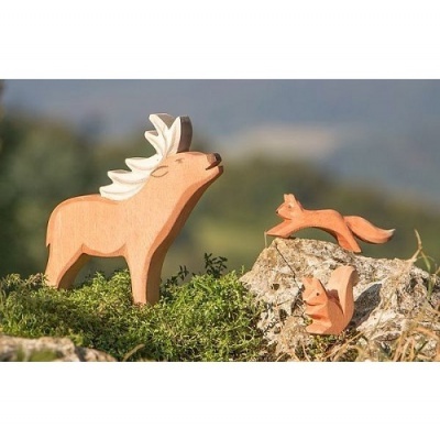Figuras de madeira de animais: alce, raposa e esquilo num ambiente natural