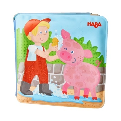 Livro de banho infantil com ilustração de criança a lavar um porco