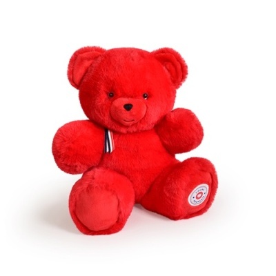 Urso de peluche vermelho macio com laço vermelho, branco e azul e etiqueta redonda no pé.