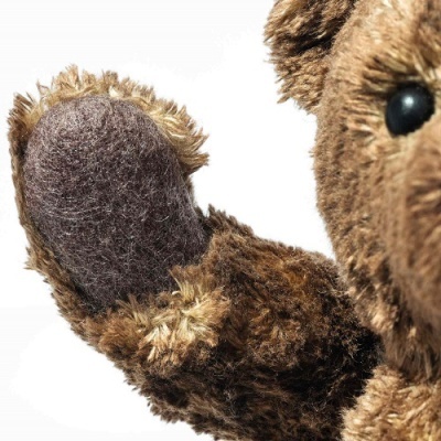 Urso de peluche castanho com pata de feltro cinzento e olho preto