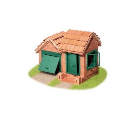 Miniatura de casa em tijolos com porta, portão e janela verdes