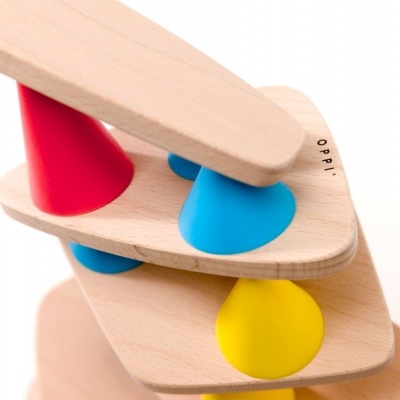 Escultura de madeira com cones coloridos e texto 'opelo'.