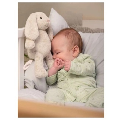 Boneco de peluche coelho branco com bebé a dormir em cama