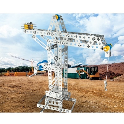 Guindaste metálico prateado com roldanas amarelas e azuis num canteiro de obras