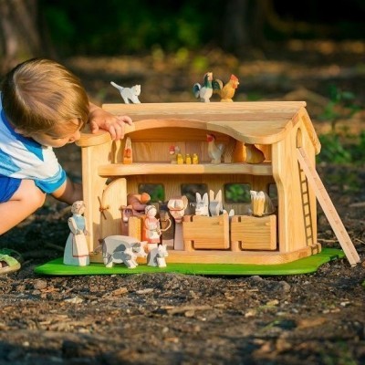 Casa de madeira temática de quinta com figuras de animais e pessoas, em exterior