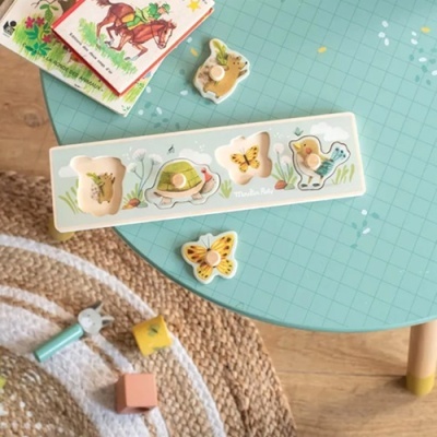 Puzzle em madeira com imagens de animais e plantas sobre mesa azul