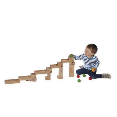 Criança brinca com brinquedo de madeira para bolas coloridas em fundo branco