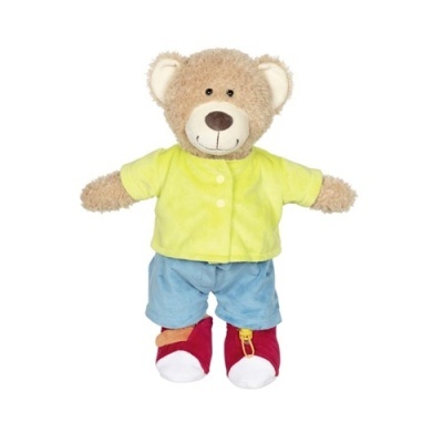 Urso de peluche castanho claro vestido com camisa amarela, calças azuis e sapatos vermelhos.
