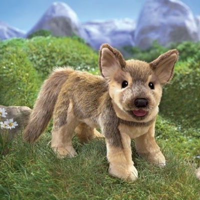 Pelúcia cão castanho e bege em relva verde artificial