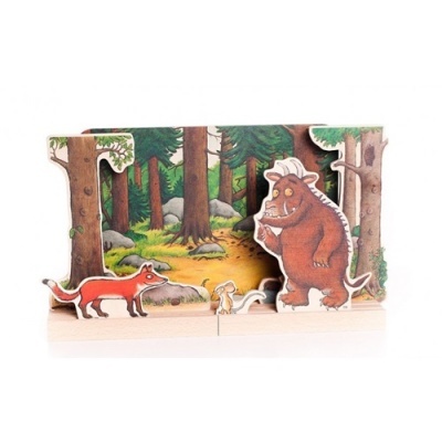 Brinquedos de madeira com personagens de raposa, coelho e criatura num cenário de floresta