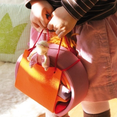 Brinquedo infantil de tecido com boneca de pelúcia e bolsa laranja
