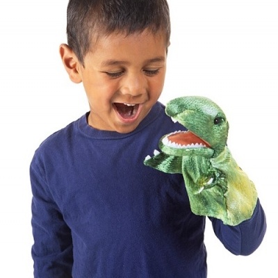 Criança a brincar com marioneta de dinossauro verde