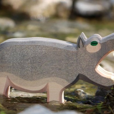 Figura de hipopótamo de madeira pintada em ambiente natural