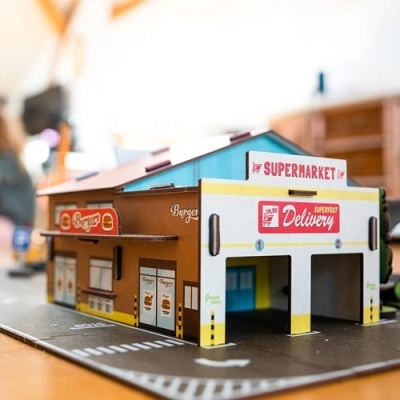 Miniatura de supermercado em cartão com texto e imagens de hambúrgueres