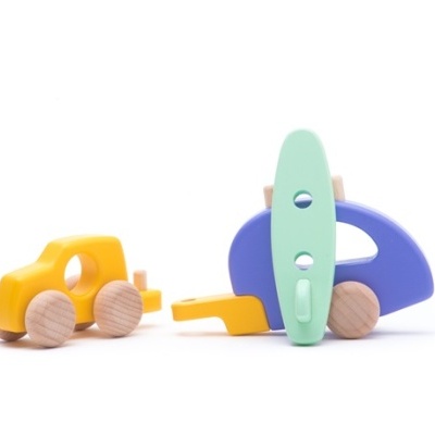 Brinquedos de madeira coloridos com rodas naturais sobre fundo branco.