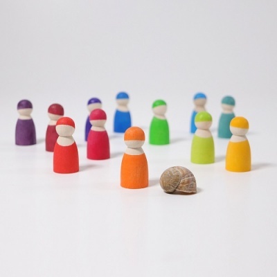 Peões de madeira coloridos e uma concha de caracol sobre superfície branca