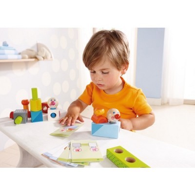 Criança a brincar com brinquedos de madeira coloridos numa mesa.