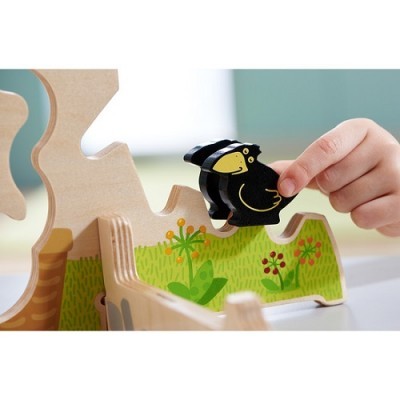 Brinquedo de madeira com pássaro preto e base decorada com flores