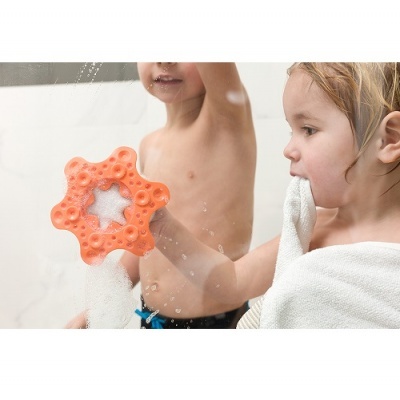 Crianças na casa de banho a usar esponja de banho laranja em forma de estrela