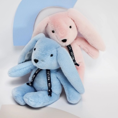 Dois coelhos de peluche azul e cor de rosa com fitas pretas no pescoço
