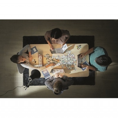 Pessoas a jogar jogo de tabuleiro com cartas e blocos de madeira em mesa clara sobre tapete preto