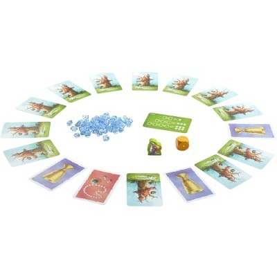 Jogo de cartas com cartas ilustradas, peças azuis, dado amarelo e cartão verde sobre superfície branca