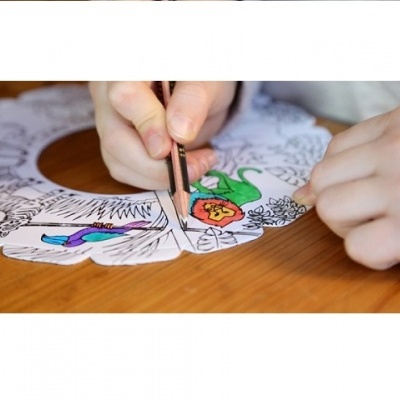 Mãos a colorir desenhos de animais num papel circular