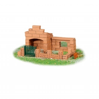 Miniatura de churrasqueira em tijolos com grades verdes sobre relva artificial